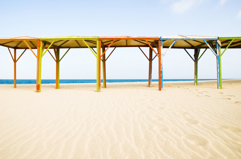 A row of colorful canopies along a stunning sandy beach on the island of Sal